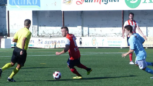 Daniel Marqués jugador del Sabiñanigo conduce el balón ante la presión de un rival.