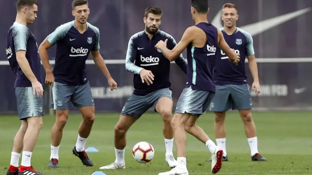 Varios jugadores del Barcelona, entre ellos el central Piqué, durante el entrenamiento de este sábado en la Ciudad Condal.