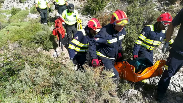 Los bomberos rescatan el cuerpo, que ha sido localizado a 25 metros del coche