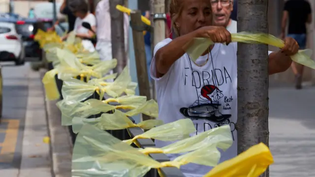 Una mujer coloca lazos amarillos en la localidad barcelonesa de Alella.