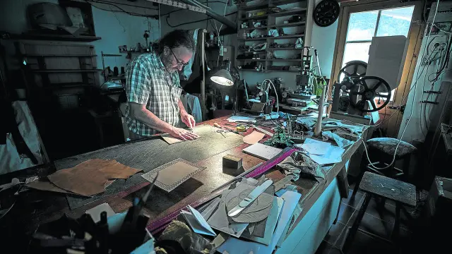 Santiago Lozano, artesano del cuero y la madera, trabaja en su taller de Boltaña.