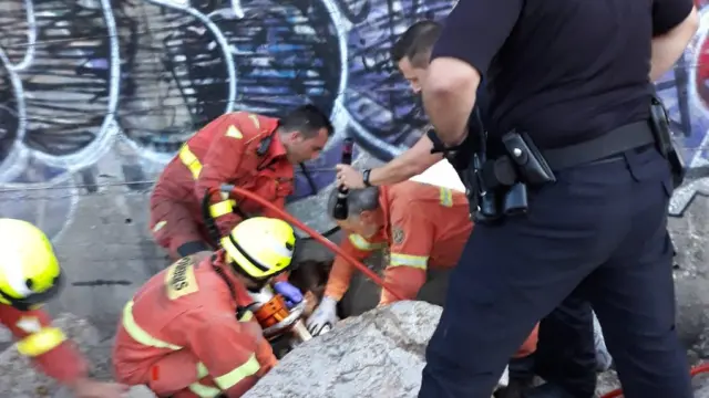 Bomberos de Paterna tratan de rescatar a la menor atrapada entre dos piedras.