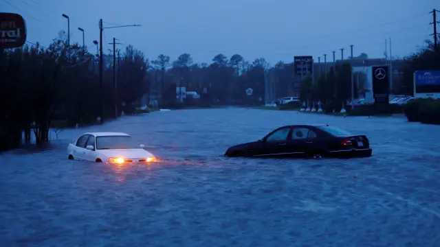 Dos coches en una zona inundada tras el paso del huracán