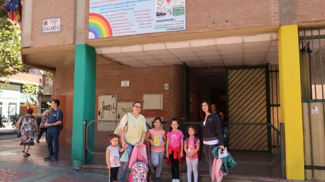 Dos madres y sus hijas, en la puerta del colegio Emilio Moreno Calvete, que está pendiente de las obras para un comedor.