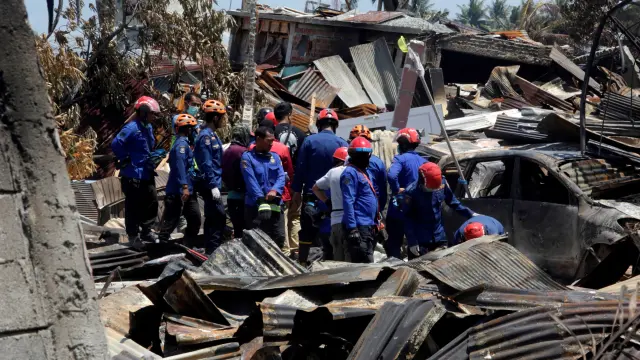 Bomberos trabajan en las labores de búsqueda tras el terremoto y posterior tsunami en las calles de Palu.