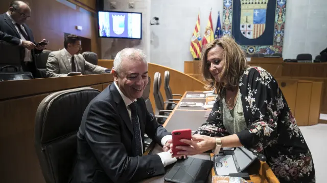 Javier Campoy (PP) conversa con la consejera de Educación Mayte Pérez (PSOE) en un descanso del pleno de las Cortes de este viernes.