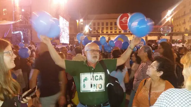 Varios miembros de la Red de Agua Pública  de Aragón (RAPA), con globos y silbatos, se concentra en contra del ICA bajo el balcón del Ayuntamiento de Zaragoza.