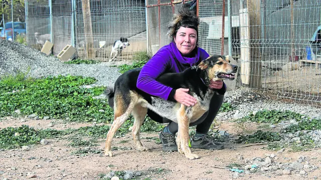 Ana, voluntaria de Amigo Mío, y Bolo, el perro que más tiempo lleva en las precarias instalaciones.
