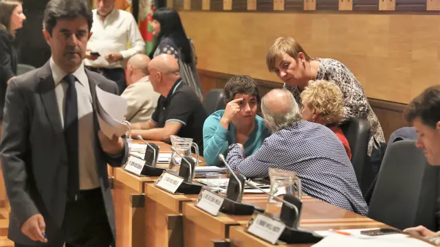 El alcalde de Huesc,a el socialista Luis Felipe, sale del salón de plenos para un receso. A su izquierda, los concejales de Cambiar Huesca hablando.