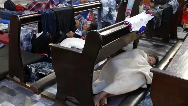 Migrantes de la caravana descansan en una iglesia de en la ciudad de Puebla