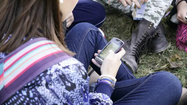 Imagen de archivo de jóvenes usando móviles.