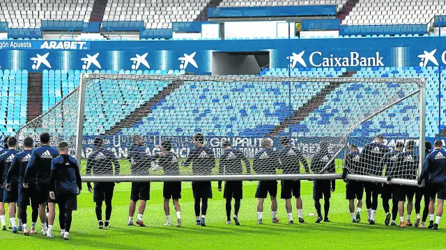 Los futbolistas del Real Zaragoza transportan una portería antes del entrenamiento de ayer.
