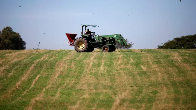 Un granjero trabajando con su tractor.