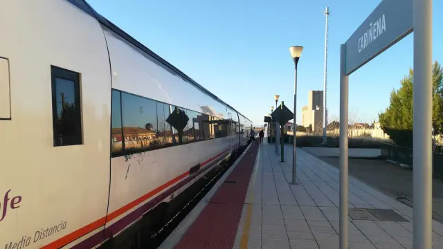 Dos viajeros suben al tren en dirección a Zaragoza en la estación de Cariñena.