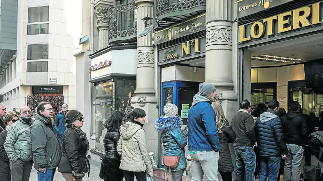 Clientes haciendo fila este viernes ante la administración de lotería número 1 de Zaragoza, en el Coso