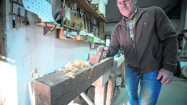 Eduardo Condón saca virutas de madera en el taller de su casa.