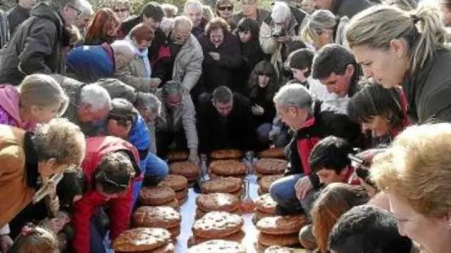 Los participantes en la romería buscan los langostos para ver el color que predice las cosechas