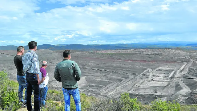 El alcalde de Ariño, Joaquín Noé, y un grupo de trabajadores observan la mina que se cierra