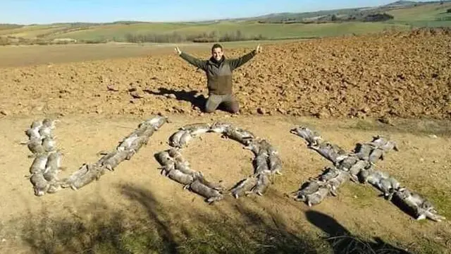 Un cazador posa con decenas de conejos muertos formando la palabra Vox.