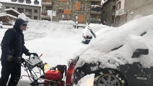 Así ha amanecido Benasque este jueves, con los coches casi enterrados por la nieve.