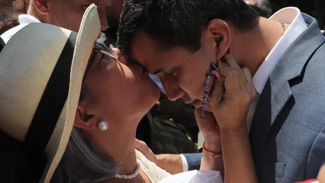 El presidente de la Asamblea Nacional de Venezuela, Juan Guaidó (d), recibe un beso de su madre, Norka Márquez, antes de hablar ante los asistentes a una manifestación en su apoyo y en contra del presidente de Venezuela, Nicolás Maduro, este sábado, en Caracas (Venezuela).