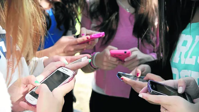 Imagen de jóvenes utilizando su teléfono móvil en Zaragoza.