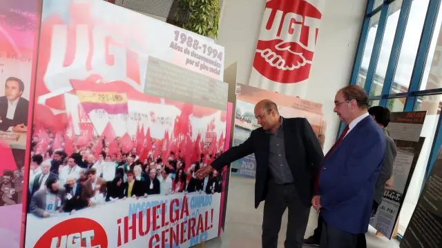 El secretario general de UGT Aragón, Daniel Alastuey, muestra a Javier Lambán, presidente del Gobierno de Aragón, imágenes de algunas de las huelgas más representativas vividas en España.