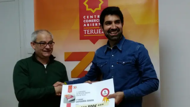 javier Gómez, del Centro Comercial Abierto, entrega el premio de relatos a Javier Lizaga.