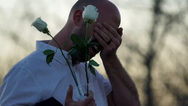 Un superviviente del tiroteo llora ante el memorial que recuerda a las víctimas