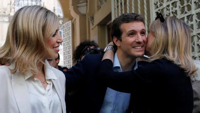Pablo Casado con su mujer, Isabel Torres, y una votante, después de ejercer su derecho al voto este domingo