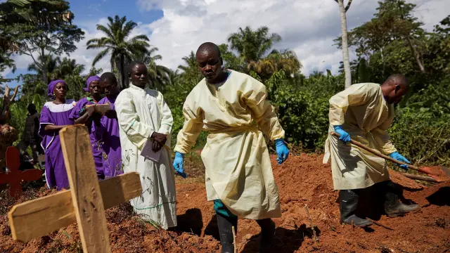 Varios trabajadores sanitarios entierran el cadáver de un hombre que se infectó con ébola tras compartir habitación de hospital con un paciente enfermo en Beni (República Democrática del Congo).