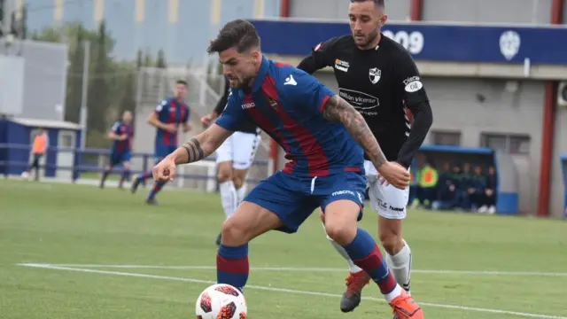 Un jugador del Levante B defiende ante la presión de un rival del CD Ebro.