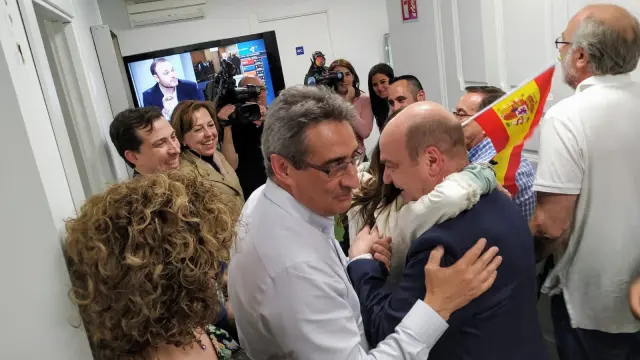 El líder de Vox en Aragón, Santiago Morón, se funde en un abrazo con una militante, al paso del nuevo concejal del partido en Zaragoza, Julio Calvo.