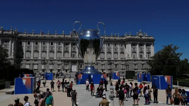People hang out next to a giant replica of the UEFA Champions League trophy that is displayed outside the Royal Palace in Madrid, Spain, May 30, 2019. REUTERS/Susana Vera [[[REUTERS VOCENTO]]] CHAMPIONS-TOT-LIV/PREVIEW