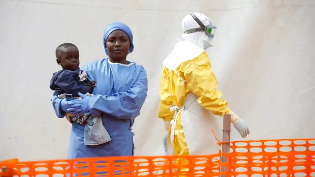 FILE PHOTO: Mwamini Kahindo, an Ebola survivor working as a caregiver to babies who are confirmed Ebola cases, holds an infant outside the red zone at the Ebola treatment centre in Butembo, Democratic Republic of Congo, March 25, 2019. REUTERS/Baz Ratner/File Photo [[[REUTERS VOCENTO]]] HEALTH-EBOLA/SOCIETY