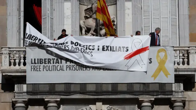 Momento en el que se sustituyo un cartel por otro en el balcón del Palau de la Generalitat