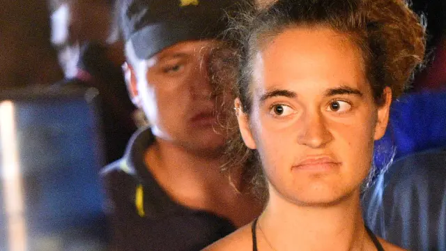 FILE PHOTO: Carola Rackete, 31-year-old Sea-Watch 3 captain, is escorted off the ship by police and taken away for questioning, in Lampedusa, Italy, June 29, 2019. REUTERS/Guglielmo Mangiapane/File Photo [[[REUTERS VOCENTO]]] EUROPE-MIGRANTS/ITALY-CAPTAIN