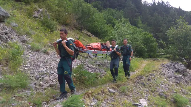 Especialistas de Jaca trasladan en camilla a un senderista herido con una lesión de tobillo en Canfranc.