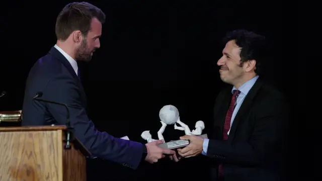 El representante de HBO, David Coupland, recibe un galardón de parte de José Antonio Gil, durante la entrega de premios de 'Amigos de España'.