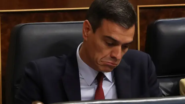 Sánchez escucha la intervención de Casado en la primera sesión del debate de investidura.