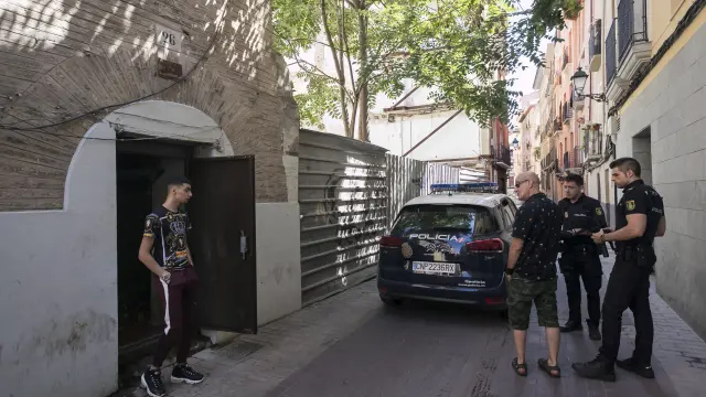Dos policías nacionales y un vecino de la calle de Agustina de Aragón hablan con un joven okupa del edificio número 26.