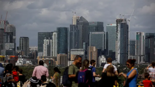 People look out onto the Canary Wharf financial district as they stand at a viewing area in Greenwich Park in London, Britain August 11, 2019. REUTERS/Simon Dawson [[[REUTERS VOCENTO]]] BRITAIN-BUSINESS/