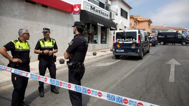 Efectivos de la Policía Nacional y Local controlan la zona junto al cadáver de la mujer de 81 años que ha sido encontrada muerta en la barriada del Puerto de la Torre, en Málaga