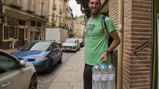 Un vecino, con seis botellas de agua que adquirió en Daroca.