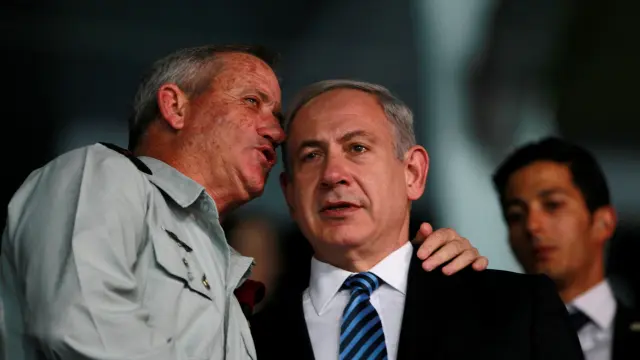 Benny Gantz (i) y Benyamin Netanyahu (d) conversando durante la ceremonia.