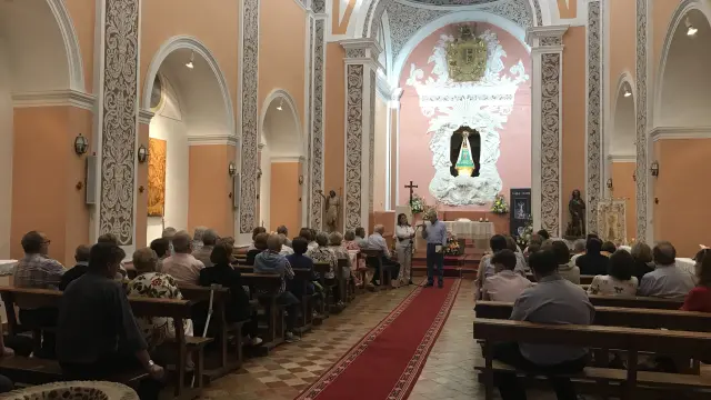 Una conferencia en la iglesia, ante el camarín de la Virgen.