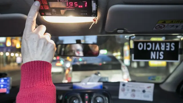 Un taxista activa un contador en el interior de su vehículo.