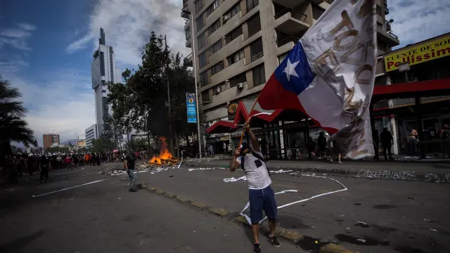 Manifestantes protestan este martes, en las calles aledañas a la céntrica Plaza Italia, en Santiago