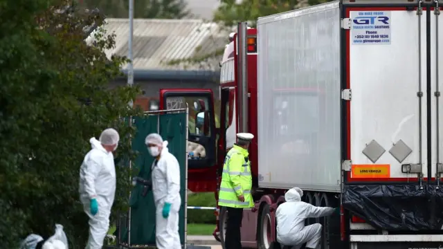 La policía examina el lugar donde fueron encontrados los cuerpos, en el interior de un camión en el Reino Unido