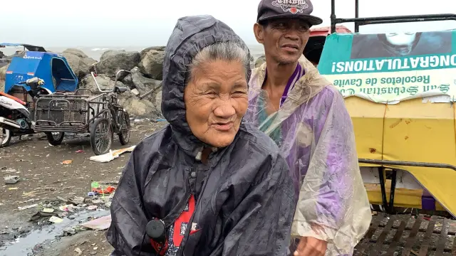 El tifón Kammuri azota Filipinas, en la imagen dos habitantes de la ciudad de Cavite